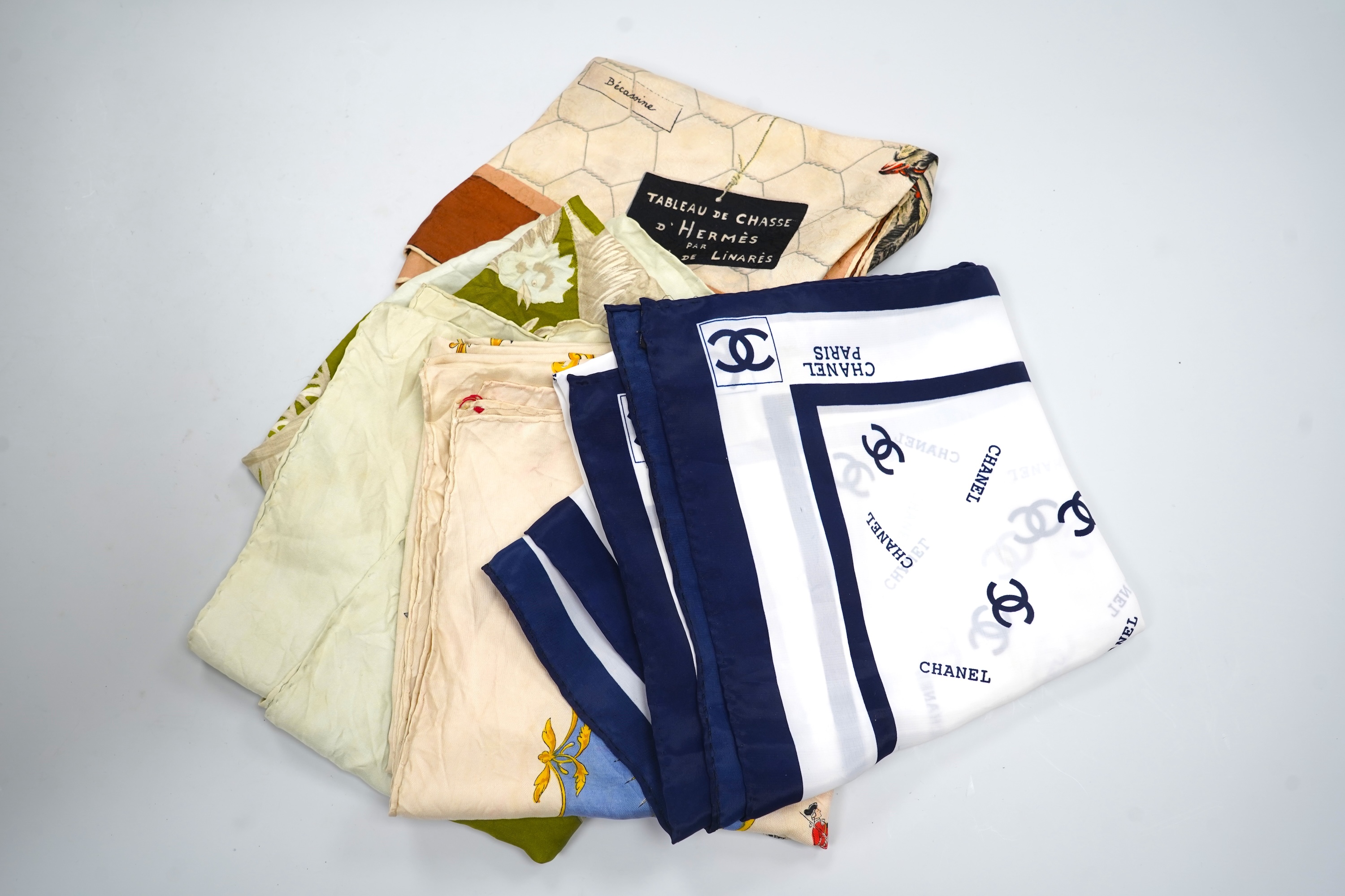 A collection of three Hermes silk scarves and a Chanel monogram example